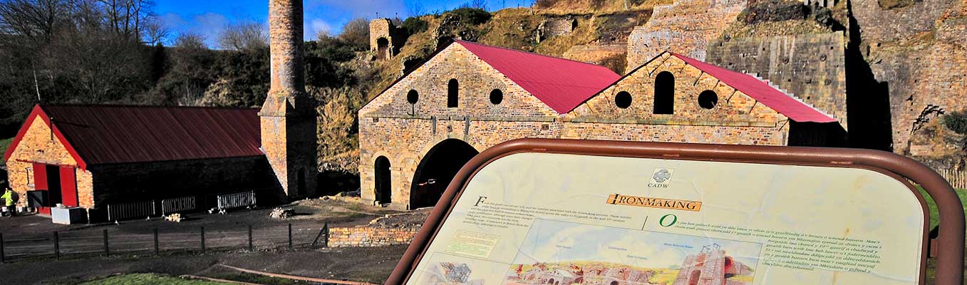 Ironmaking trail sign with Blaenavon Ironworks in the background